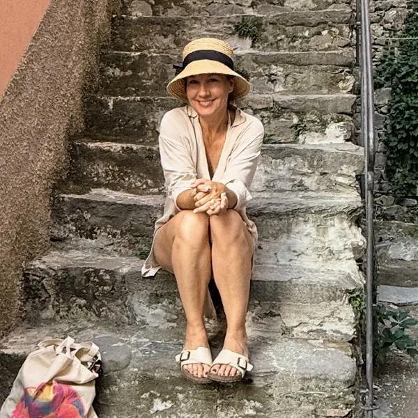 Amy sitting on stone steps in a village in Italy